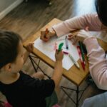 Teenage girl and young boy practicing letters at a desk.