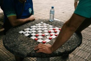 Two people playing checkers - close-up on the board.