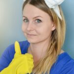 Cleaning person giving a thumbs up with her yellow-gloved- hand.