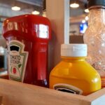 Ketchup and Mustard in a caddy on a diner table.