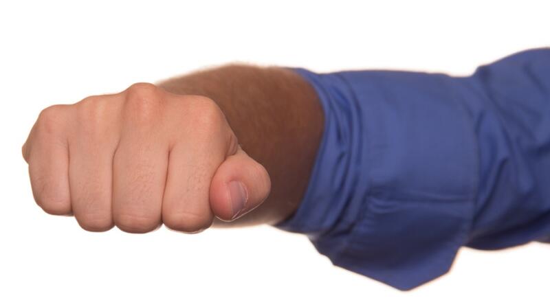 Close up of man's fist in correct position for determining distance between mic and mouth.