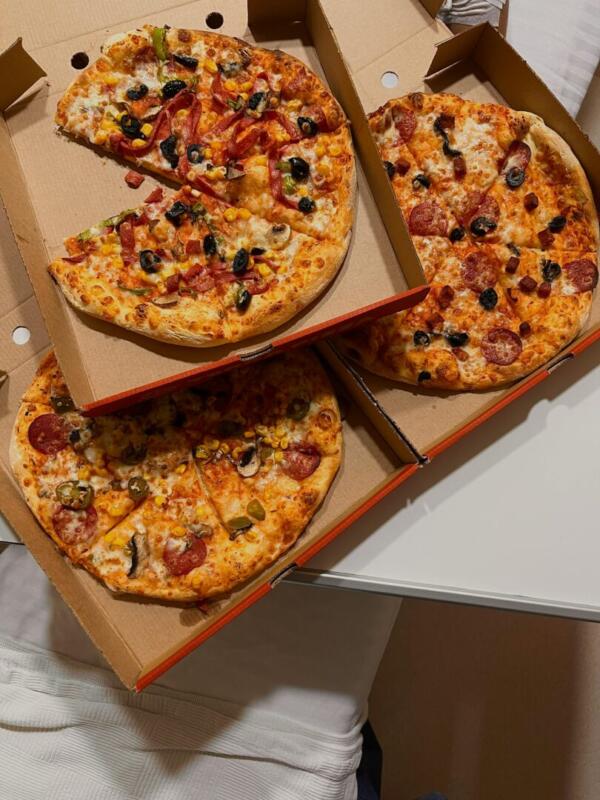 Assorted pizzas in cardboard boxes – each sliced into 8 pieces.