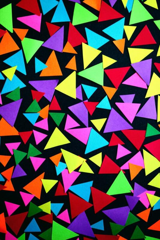 Colorful geometric triangles on a black background creating a dynamic abstract pattern.
