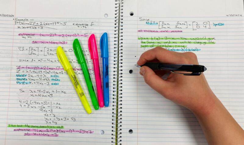 Student using visual logic and active recall techniques to solve complex math problems. This student is rewriting notes from memory and using highlighters.