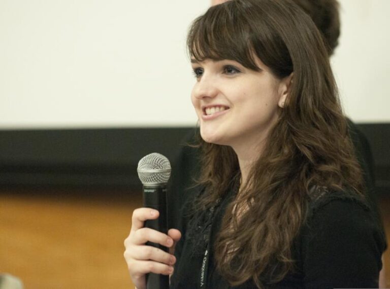 Public speaker delivering a speech using a microphone to practice enunciation.