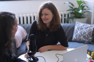 An engaging instructor coaching another woman in a one-on-one studio setting.