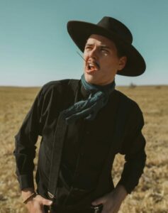 “Bad Guy” Cowboy snarling in front of a dusty prairie.