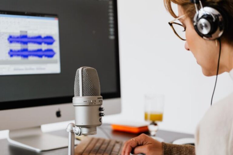 A person wearing headphones practicing speech or podcasting with a wave audio graphic on a screen.