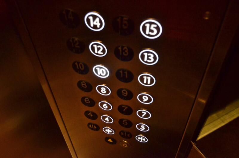 Elevator floor button panel showing floor numbers inside an apartment building.