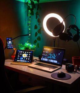 Organized workspace set up with external microphone and laptop for live online streaming.
