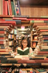 A student reading a book at The Last Bookstore where the books are artfully arranged in an open circle. 📚 Model: Ying Ge