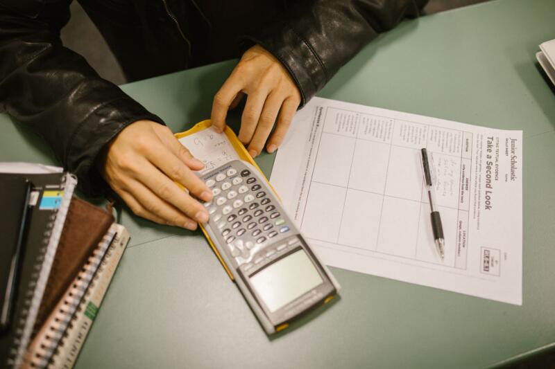 High school student solving algebra word problems with a graphing calculator for SAT prep.