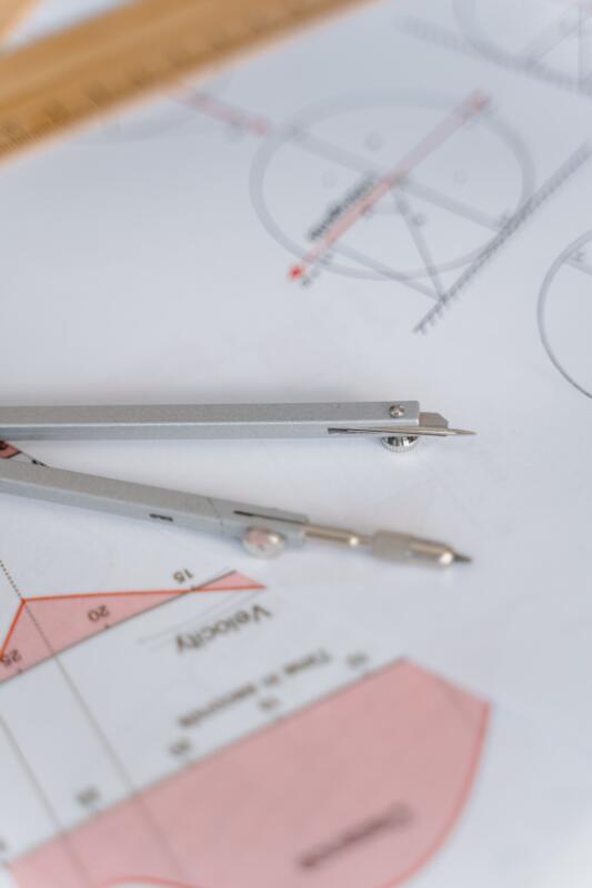 A close-up of a compass on geometric drawing paper, ideal for education and mathematics concepts.