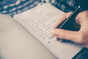 Hand writing structured speaking notes on a notepad.