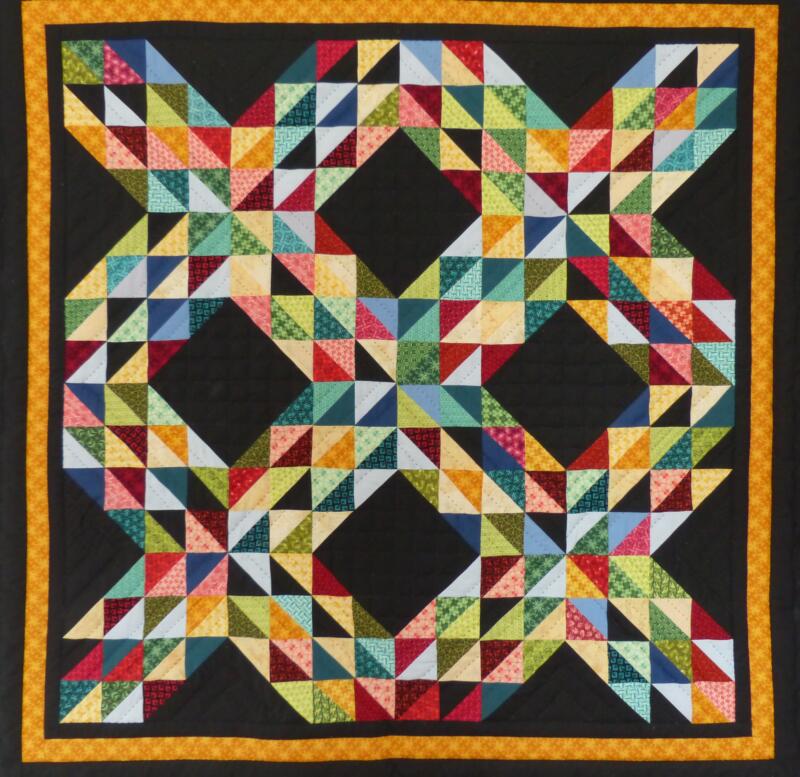 Colorful handmade patchwork quilt with geometric triangle pattern.